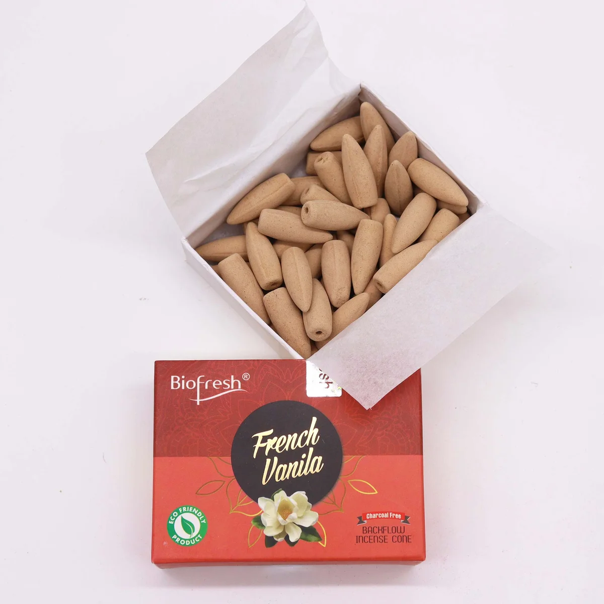 Biofresh incense cones box with French Vanilla scent and a lit backflow incense cone releasing smoke on a white background