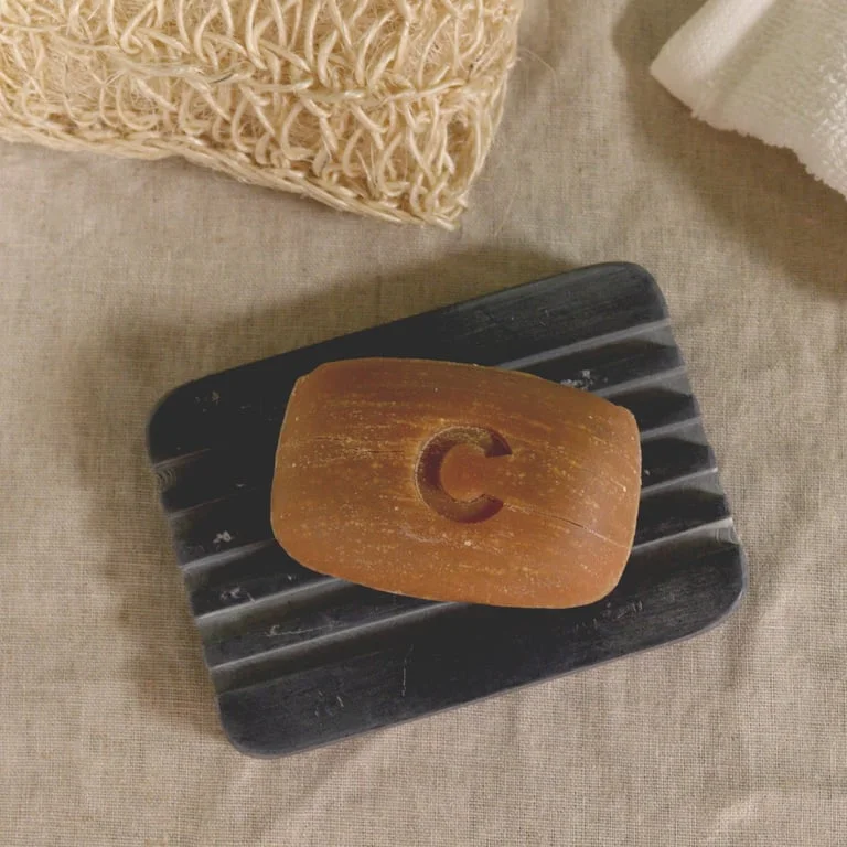 Grey soapstone soap dish with ridges measuring 12x8.5cm, designed for drainage and soap storage