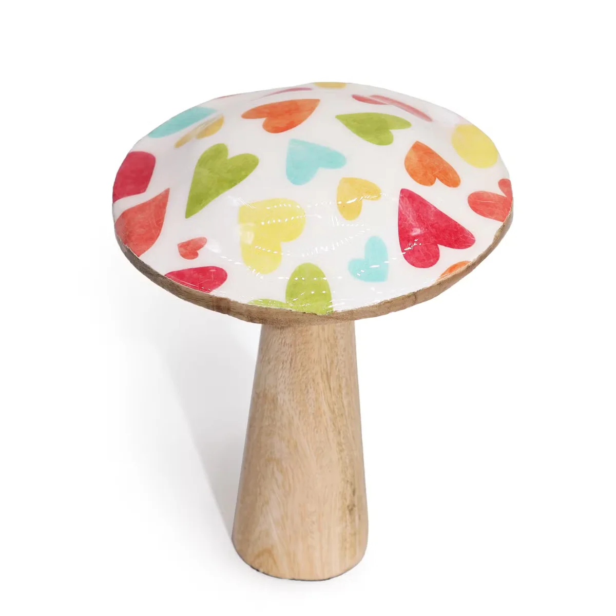 Medium wooden mushroom home ornament painted with pastel heart patterns on a plain background