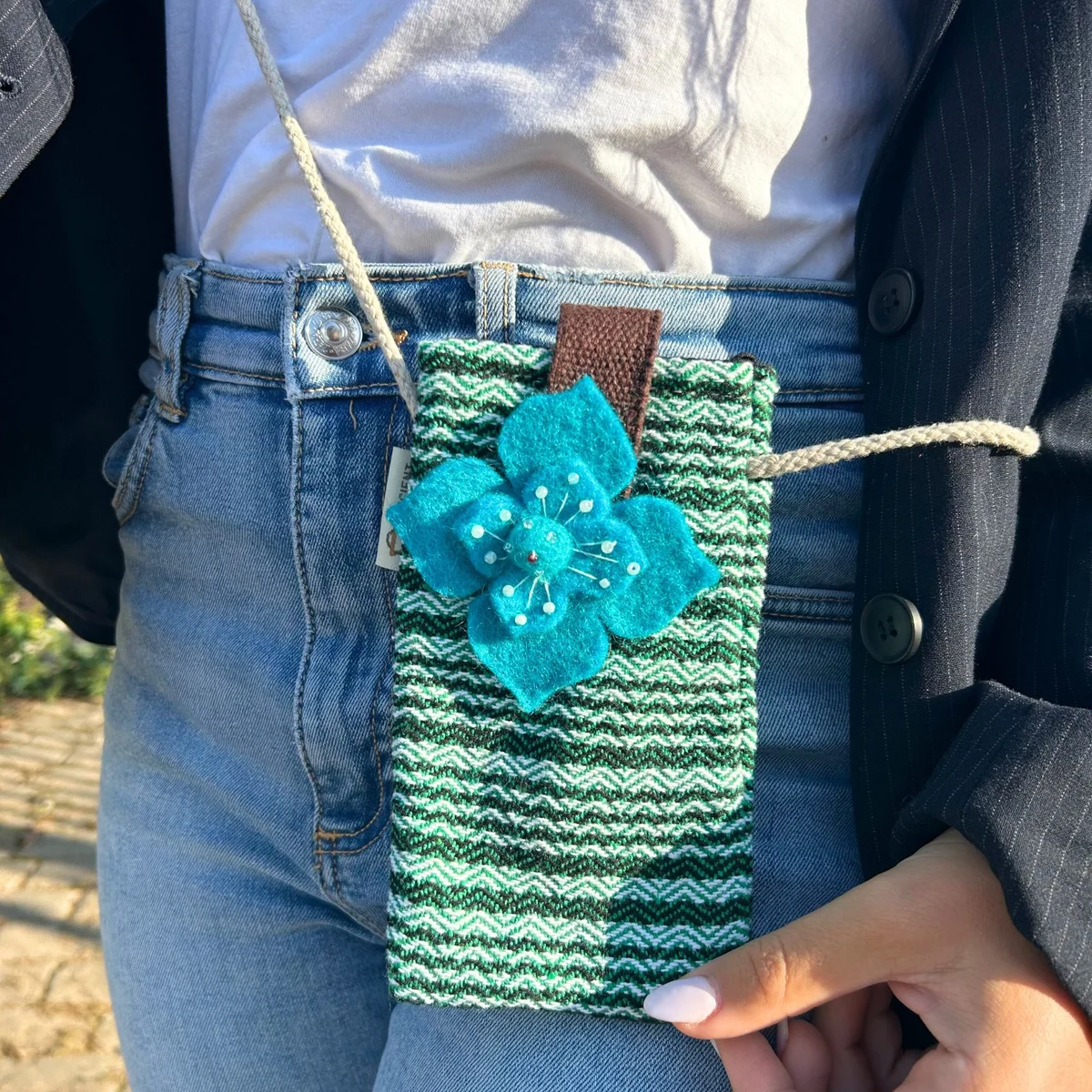 Green striped phone holder bag with flower decor, compact and designed for carrying phones securely
