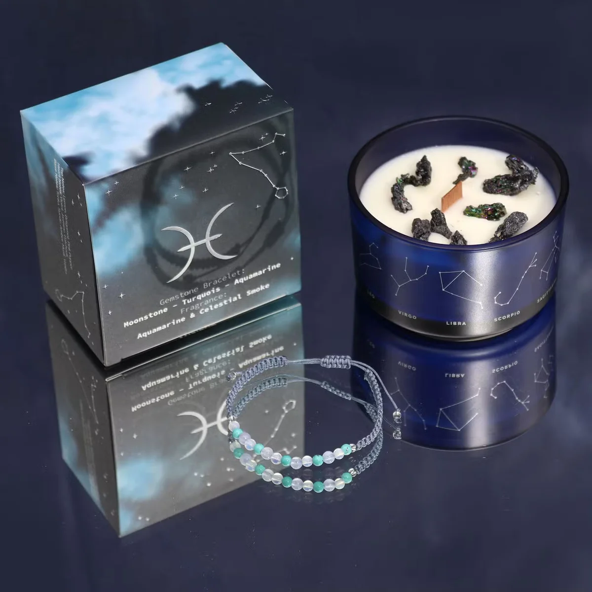 Lit Pisces candle with zodiac symbols and a matching gemstone bracelet displayed on a wooden surface