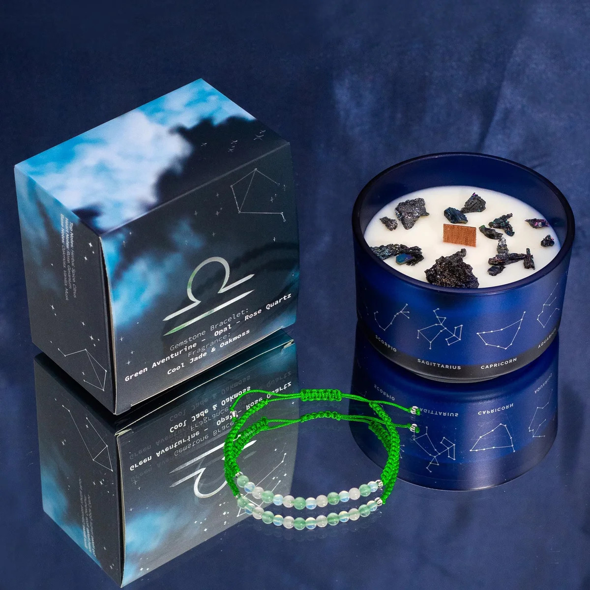 Zodiac crystal candle labeled Libra with a lit wick and a gemstone bracelet wrapped around the base on a white background