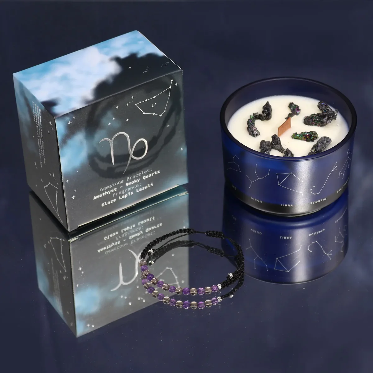 Lit Zodiac crystal candle next to a Capricorn gemstone bracelet on a white background
