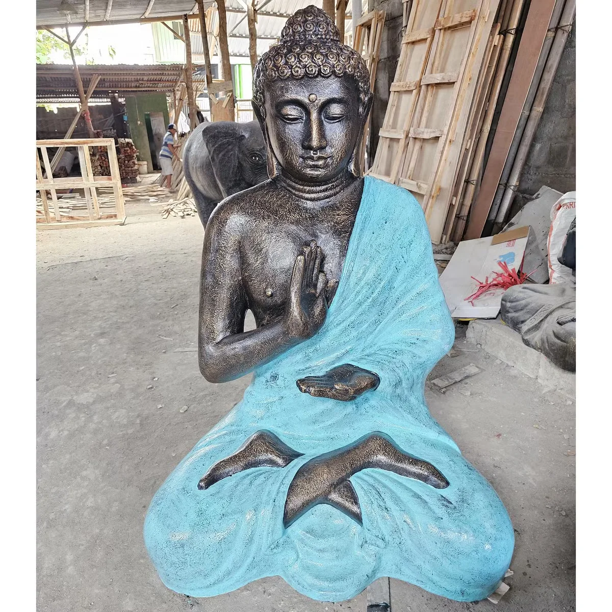Large 1.5m turquoise and stone meditation Buddha figure seated inside a stupa structure on a plain background