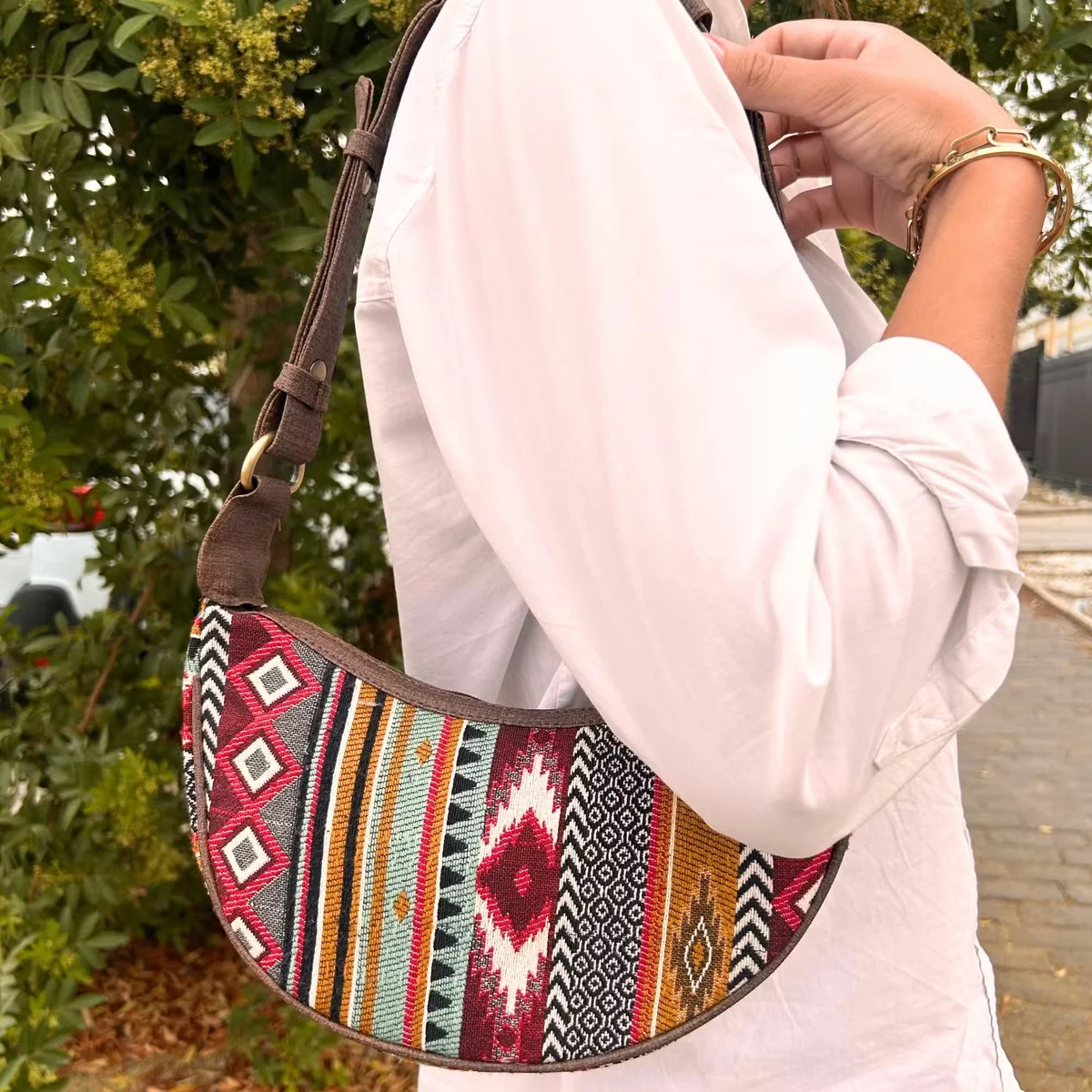Rich brown handbag with jacquard pattern, featuring a matching brown strap.