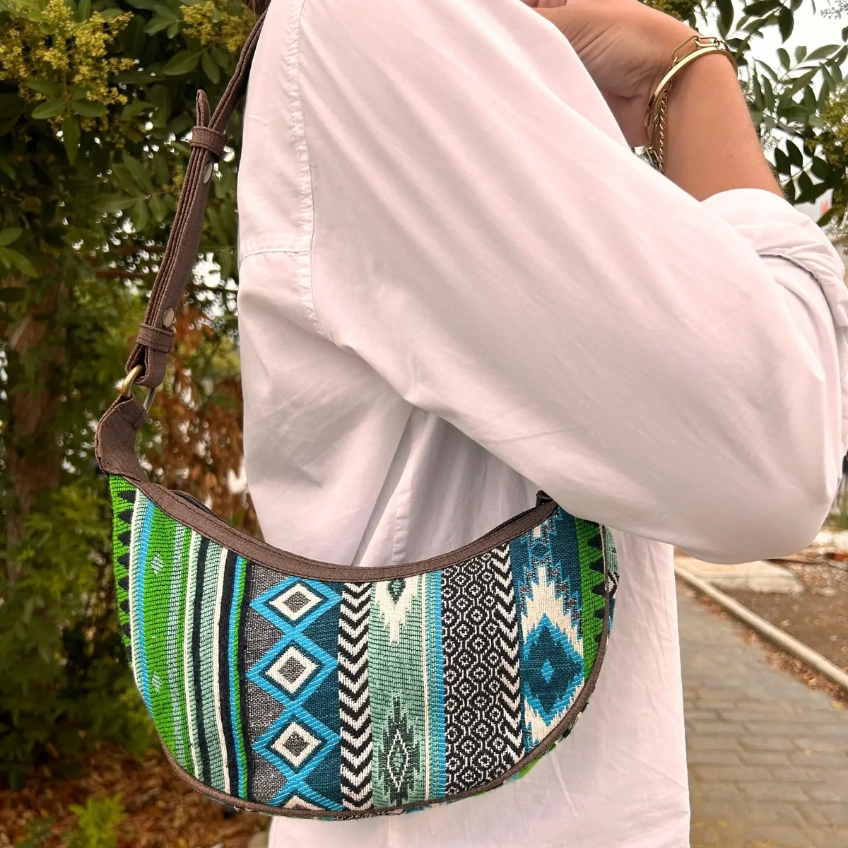 Bold greens jacquard hobo bag with brown strap displayed against white background