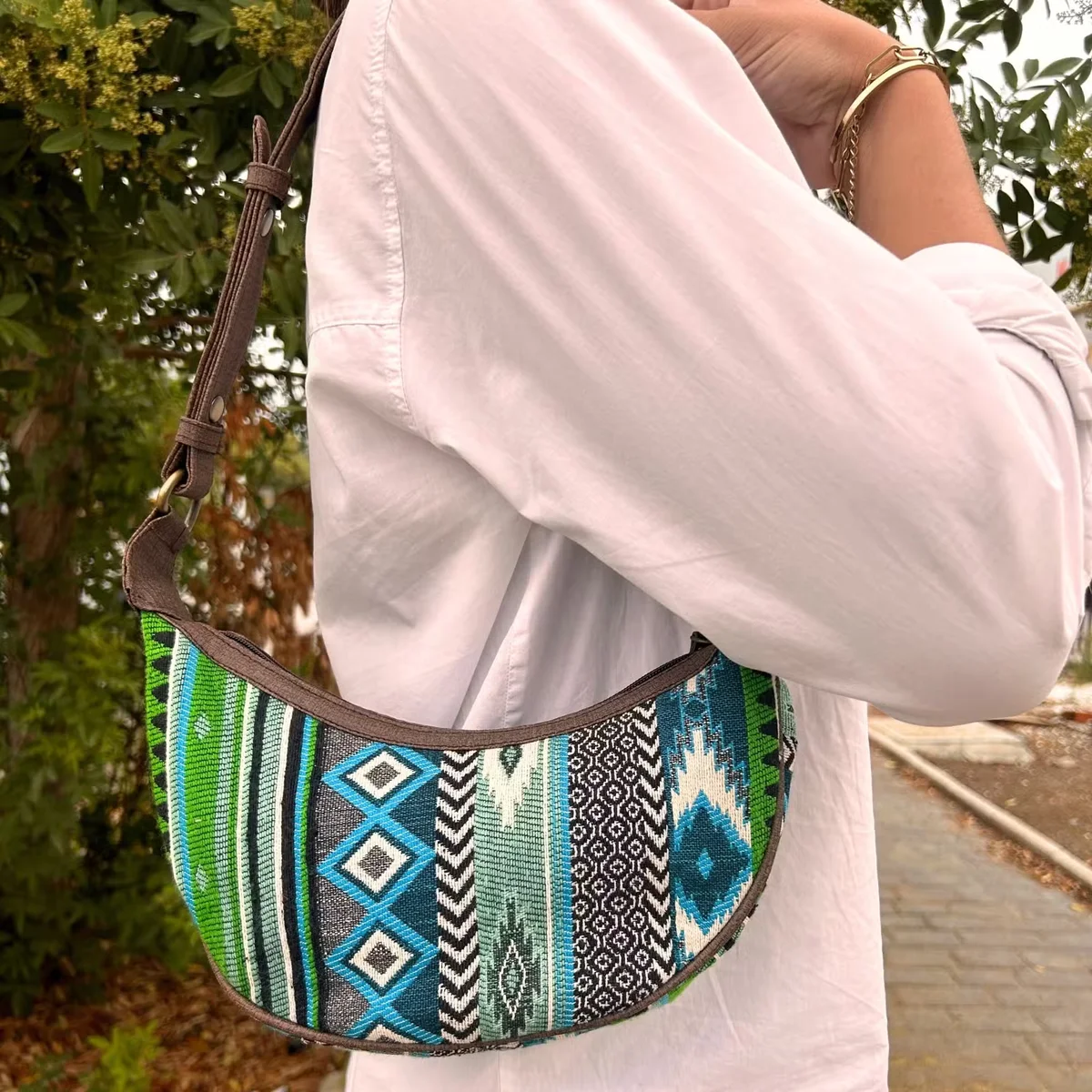 Jacquard hobo bag in bold green pattern with a brown strap bag displayed on a white background