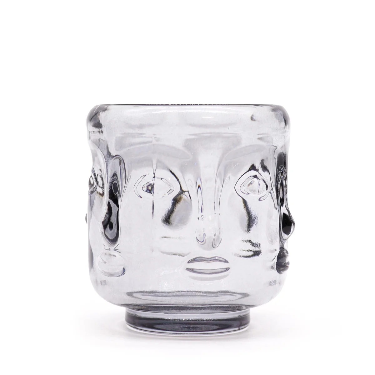 Midnight grey candle in ceramic Buddha faces jar with carved Buddha outlines, mounting on tabletop