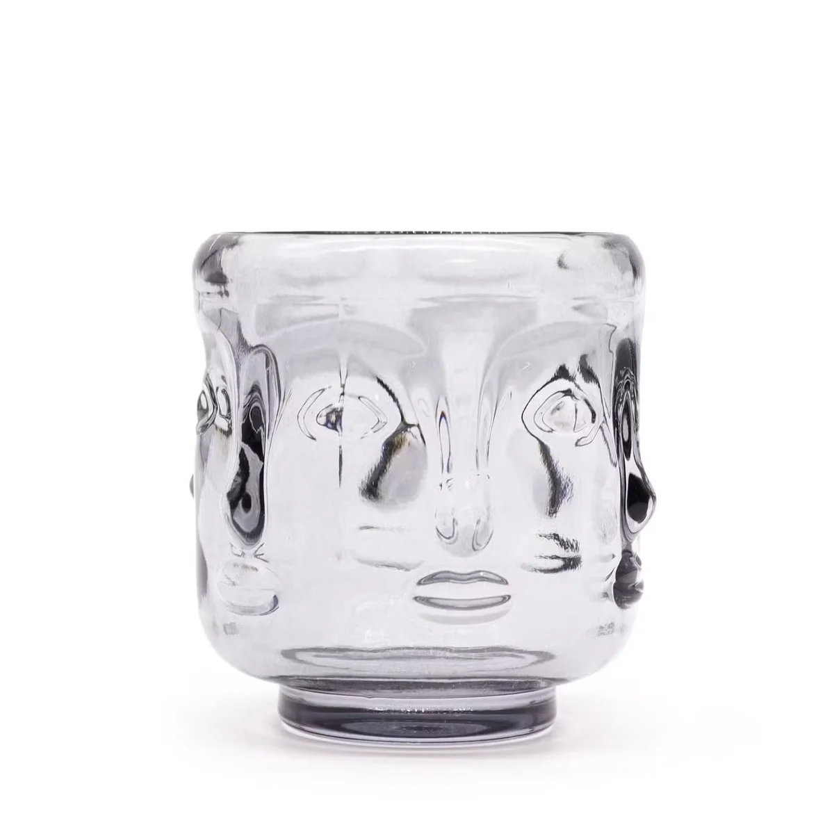 Midnight grey Buddha face candle jar featuring a carved Buddha face glowing softly.