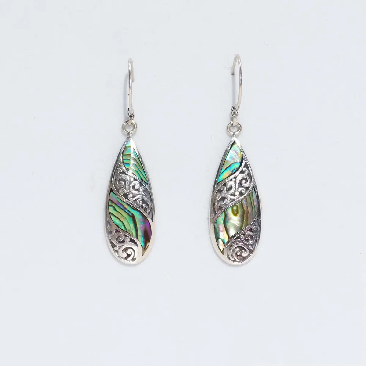 Silver drop earrings with abalone shell accents, long teardrop design.