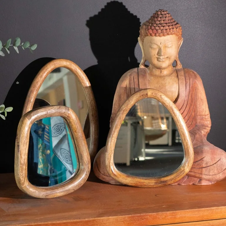 Three pebble shaped dark brown mirrors arranged on a white background showing their reflective surfaces