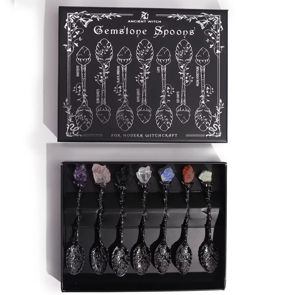 Seven dark silver spoons featuring gemstone crystal accents arranged together