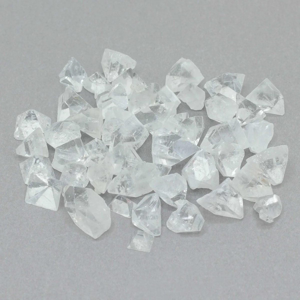 Glass container of 100g of reddish‑green Apophyllite crystal tips, 7‑10mm long, natural crystal ornaments