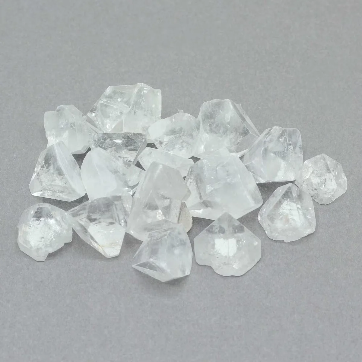 Bag of 100g apophyllite stones, medium tips 12‑20mm, neatly stacked in a lightweight container