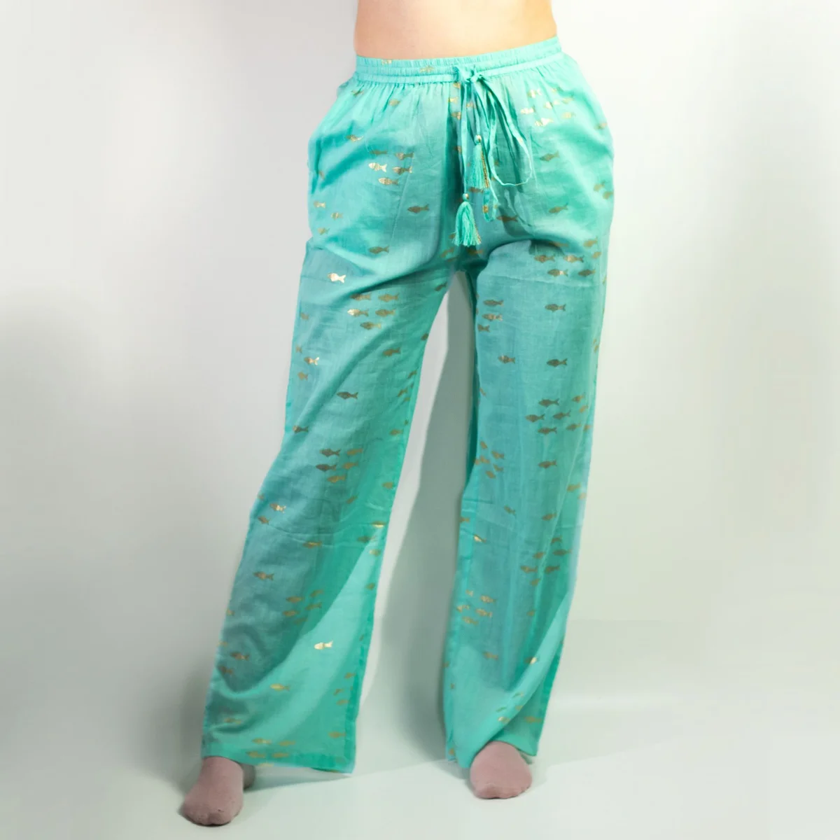 Turquoise lounge pants featuring a hand‑painted gold fish pattern