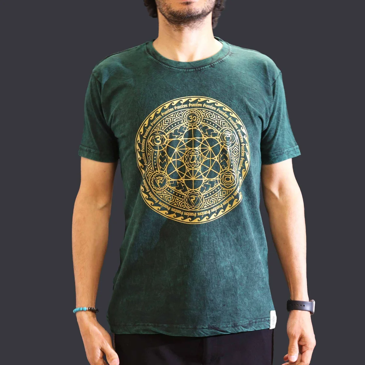 Green medium stone washed t-shirt with chakra design on front, laid flat on white background