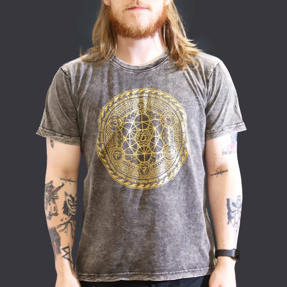 Dark grey large t-shirt with stone washed finish and chakra design on front, laid flat on white background