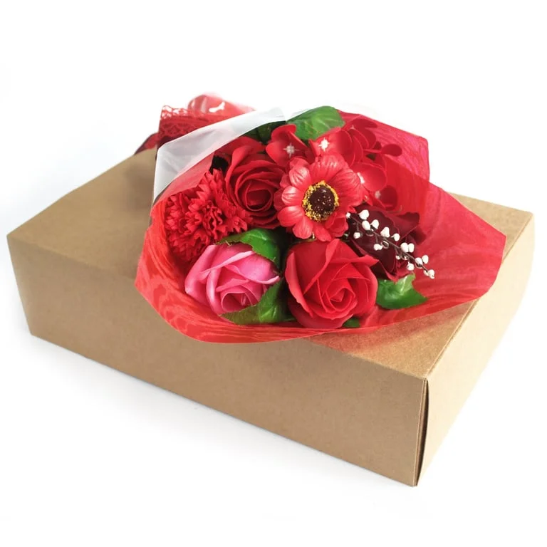 Red bouquet of flowers surrounding a small rectangular boxed hand soap