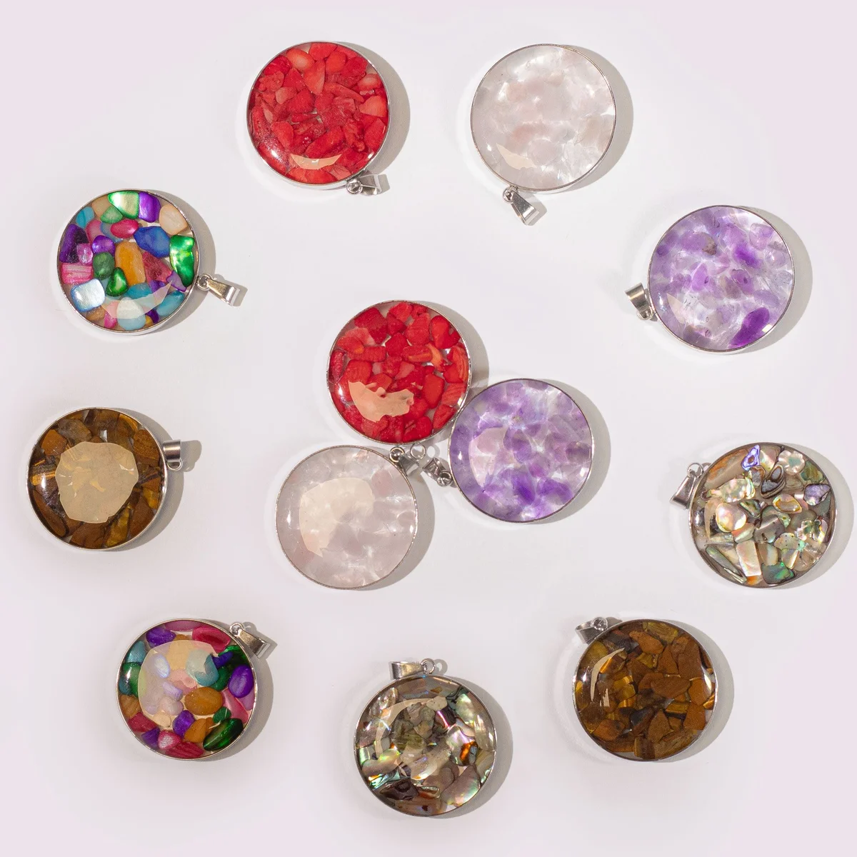 Round steel cased pendant displaying 12 assorted gemstone chips and shells
