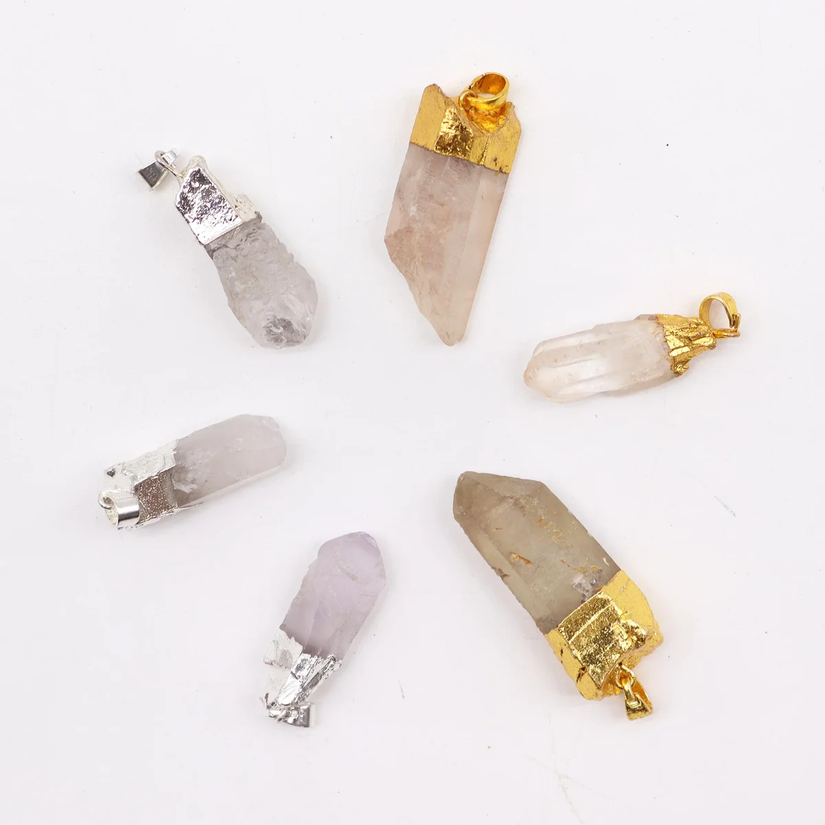 Assorted set of six clear quartz silver plated pendants, each with gold detail, hanging from necklaces.