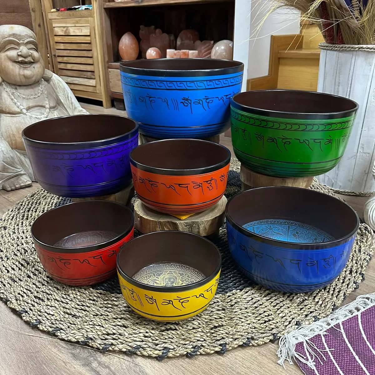 Set of seven large singing bowls in chakra colours, sizes 19.5–35 cm.