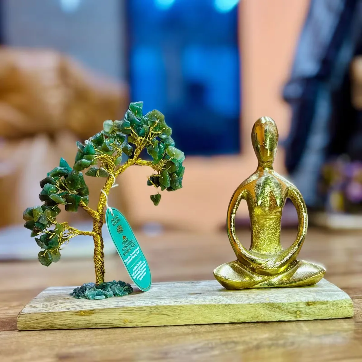 Green Aventurine chipstones arranged around a tilted tree in the Padmasana pose from the gemstone yoga garden set