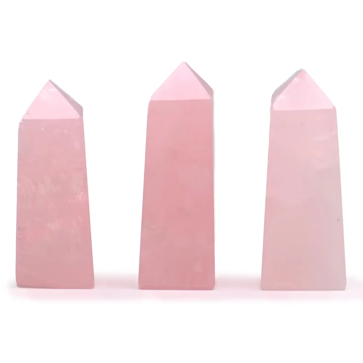 Rose Quartz crystal obelisk ornament approx 5cm tall with smooth polished surfaces on a white background