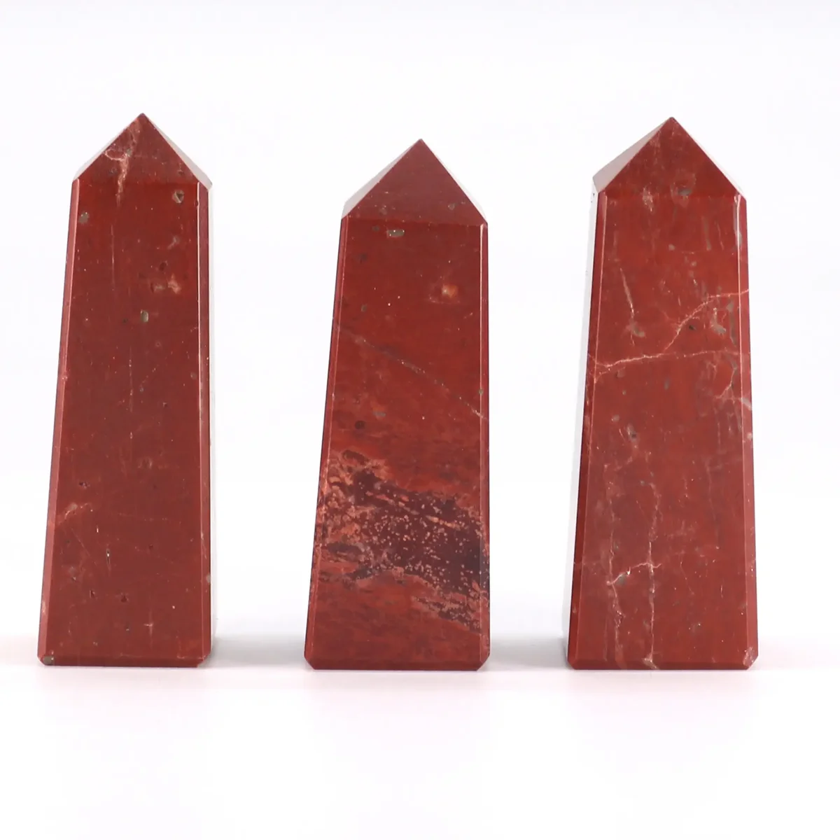 Red Jasper gemstone obelisk point approximately 5cm tall with smooth polished surface on white background
