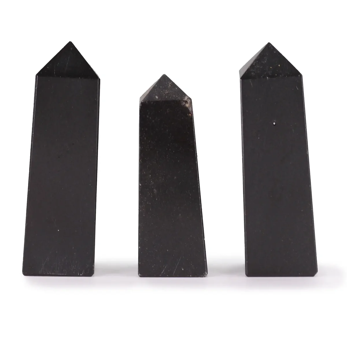Set of three 5cm tourmaline gemstone obelisk decor pieces with smooth polished surfaces on white background