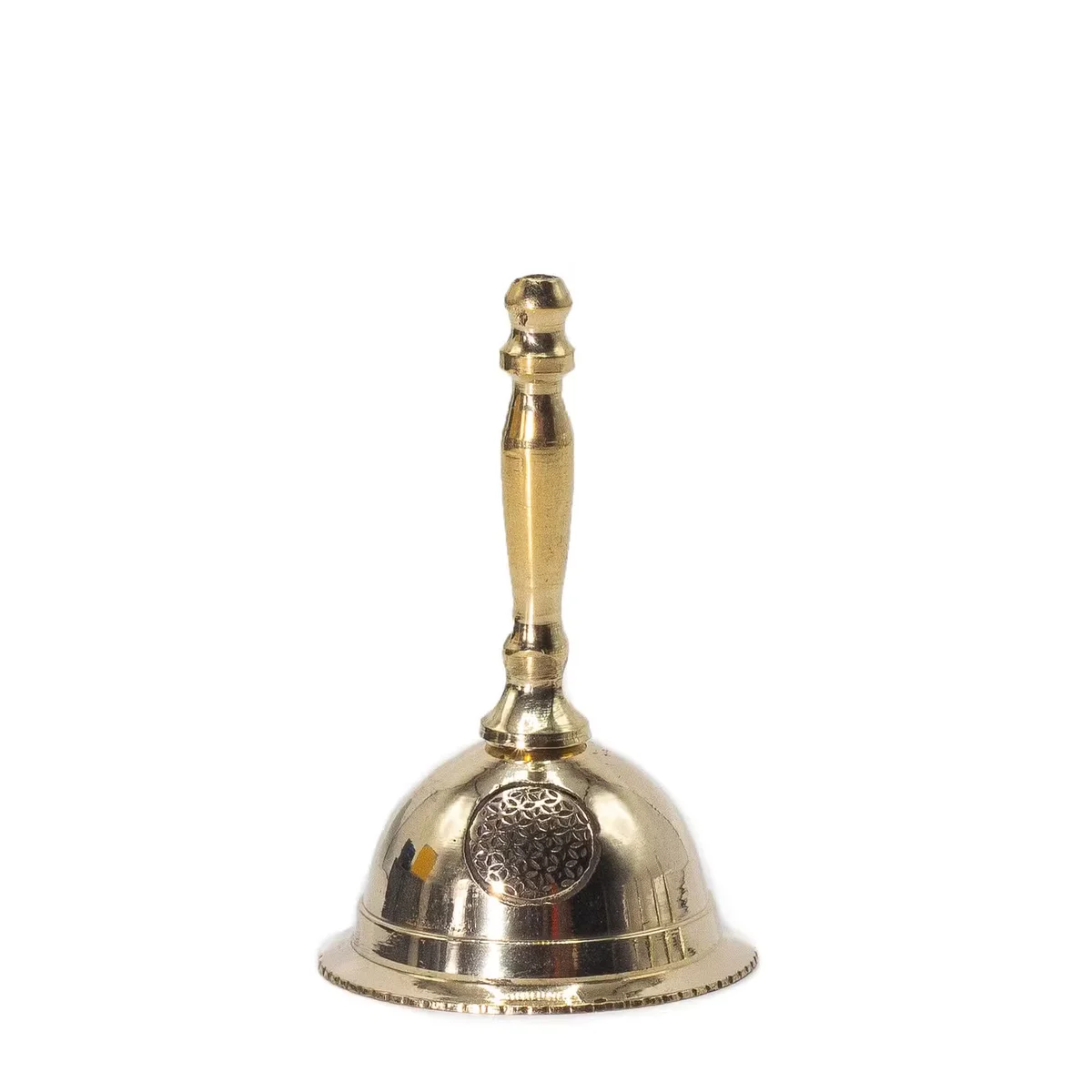 Small decorative brass bell with Flower of Life design on altar, shown on white background, third image angle
