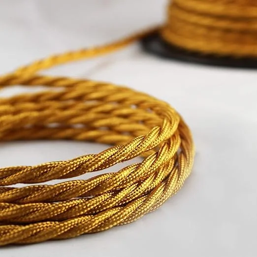Close-up of gold braided 5 meter electric wire with 3 core twisted fabric cable for indoor use