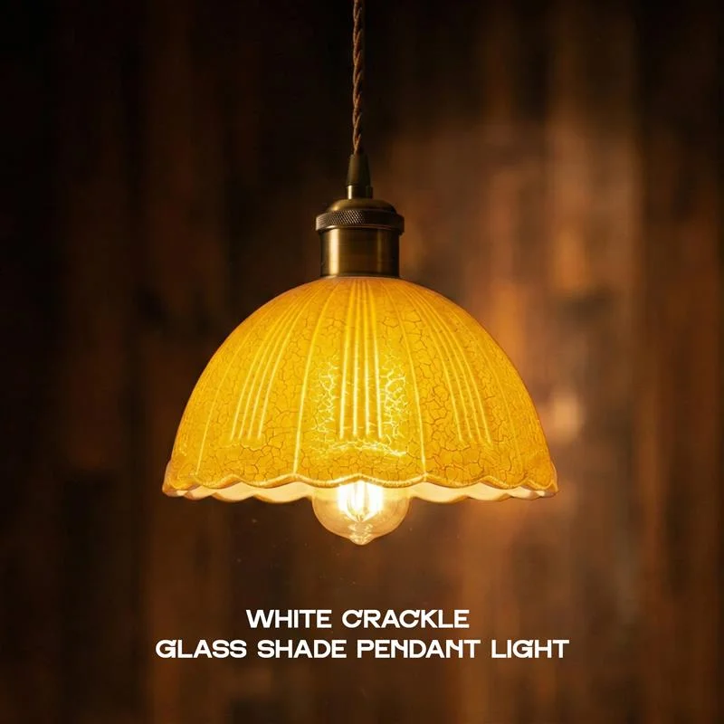 White crackle glass scalloped pendant light with brass hardware and adjustable fabric cord light hanging from ceiling