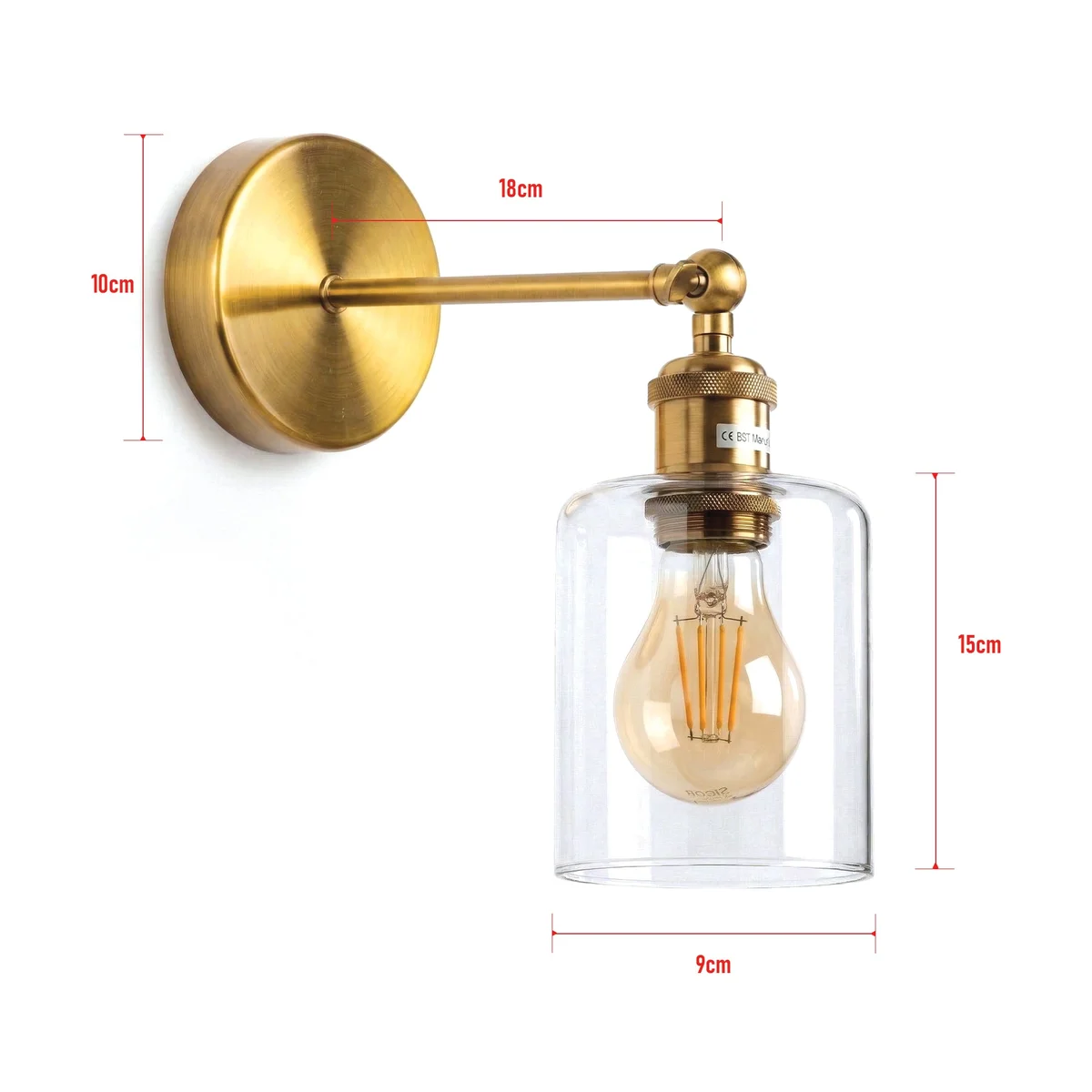 Vintage brass adjustable wall lamp with clear glass cylinder shade and warm LED bulb mounted on a yellow brass wall plate