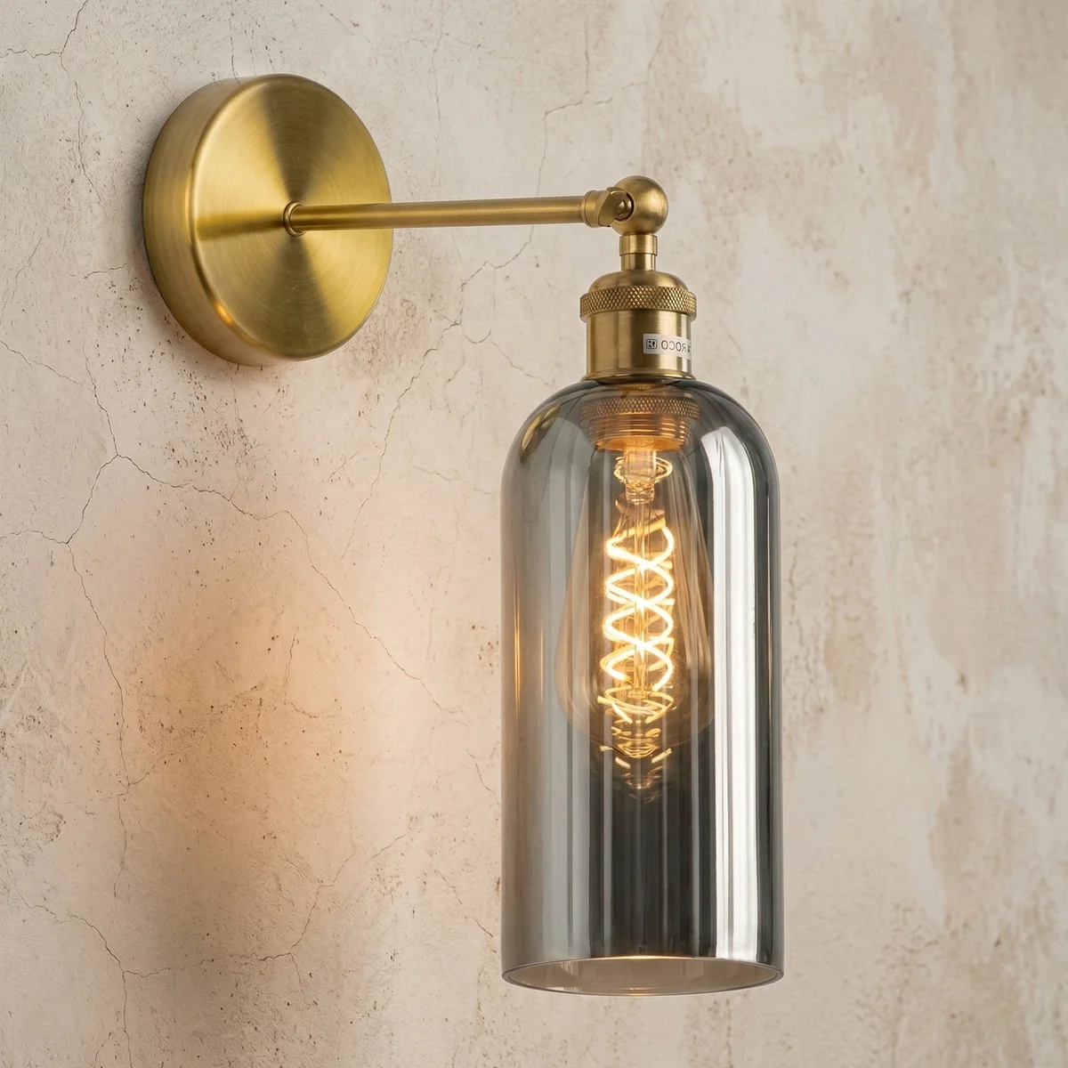 Adjustable vintage wall sconce with brass finish, smoked grey glass shade, and 180° swing arm mounted on wall