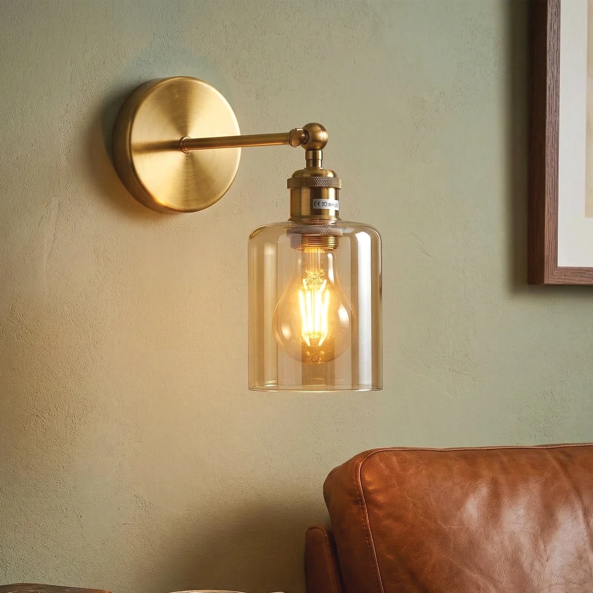 Vintage brass wall sconce with amber glass cylinder shade and adjustable 180° swing arm mounted on wall