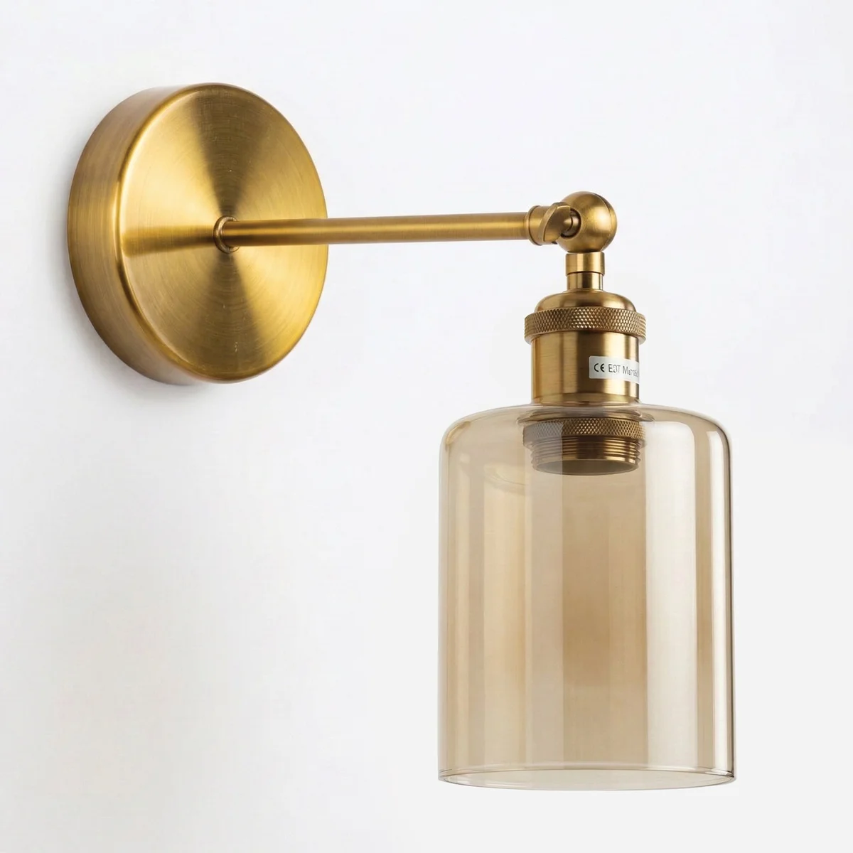 Vintage brass wall sconce with amber glass cylinder shade and adjustable 180° swing arm mounted on wall
