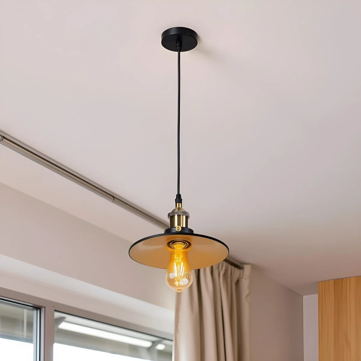 Black metal industrial pendant light with adjustable cable and classic vintage industrial design hanging from ceiling