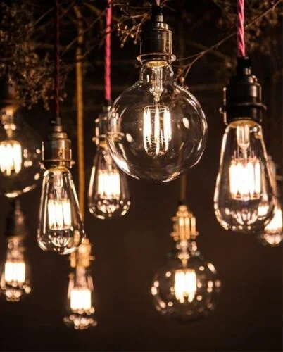 Six amber E27 LED globe bulbs with visible filaments arranged in a row on a white background