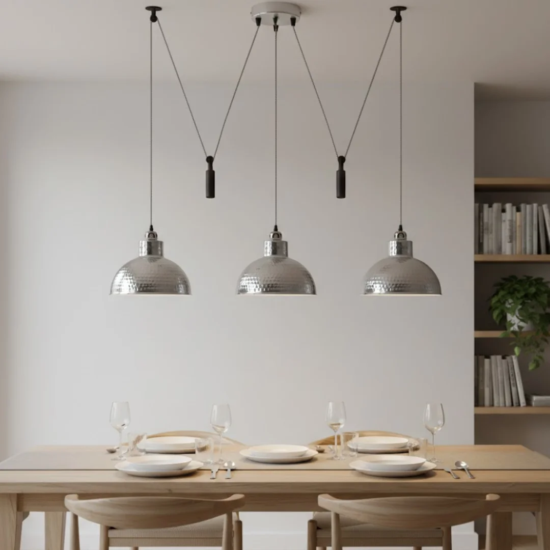 Three adjustable 2M industrial pendant lights with oxidized metal finish hanging over a dining table