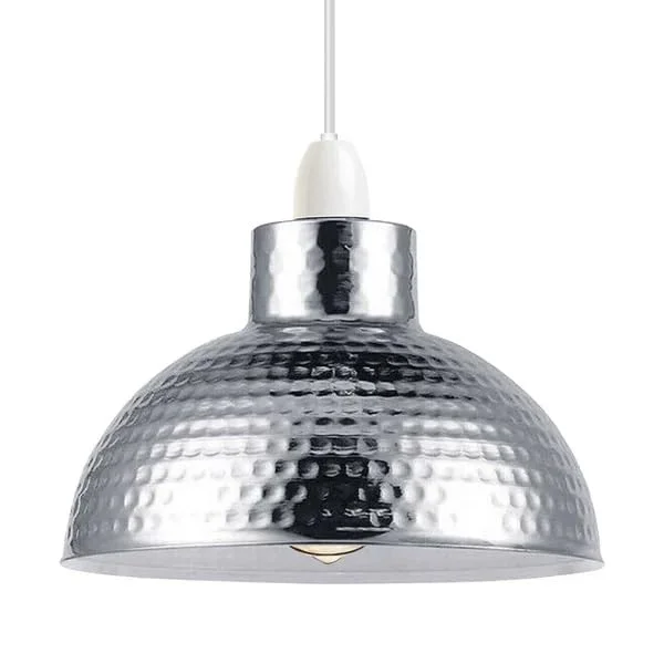 Three adjustable industrial pendant lights with oxidized metal finish hanging over a dining table in a modern setting