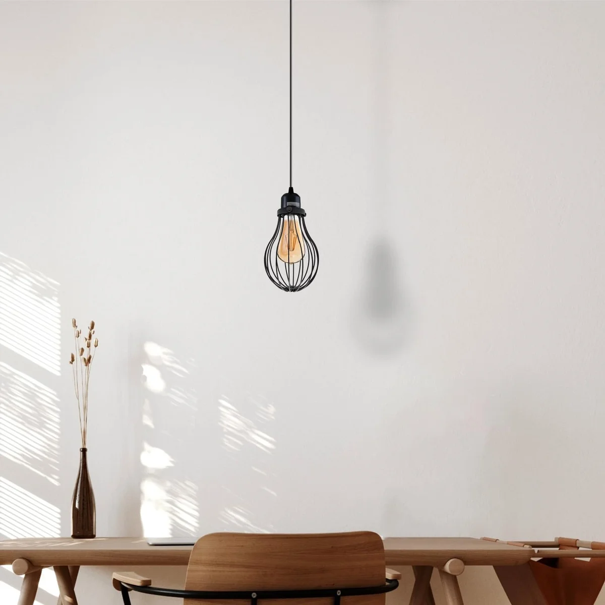 French gold pendant light with adjustable black wire cage hanging over a wooden kitchen island in modern rustic decor