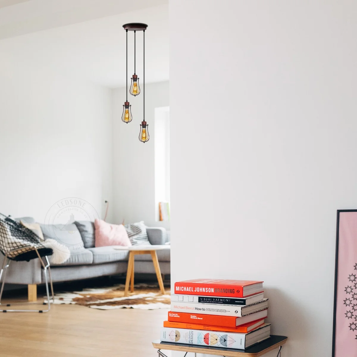 Three balloon shaped pendant lights with metal wire cages hanging from a round ceiling plate in vintage industrial style