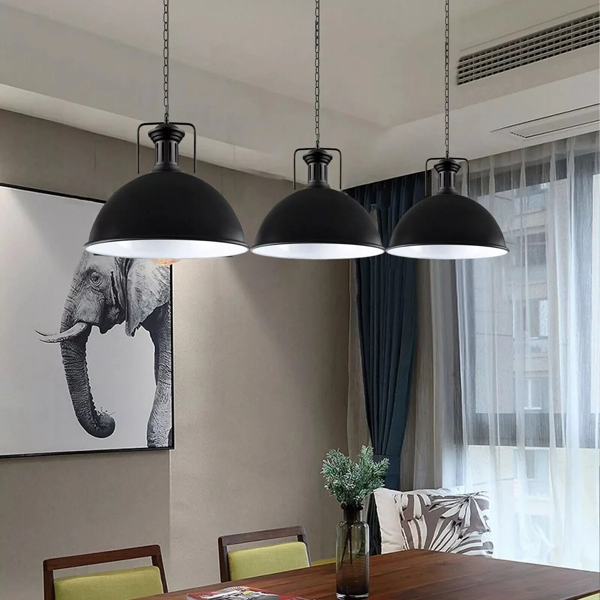 Large black industrial pendant light with metal dome shade hanging from a matching chain against a white background