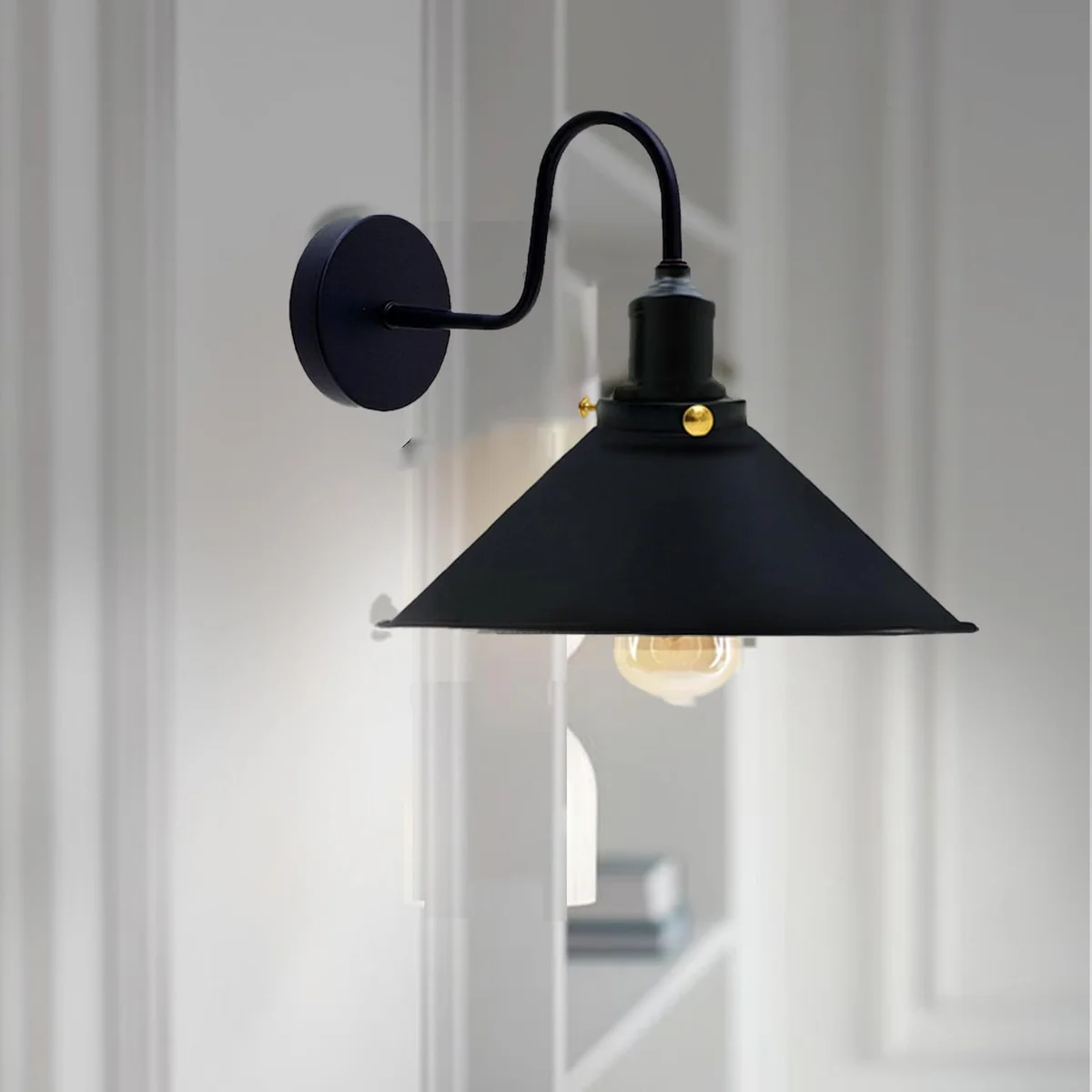 Adjustable metal cone wall light with black finish, mounted on a wall with visible arm and E27 bulb included