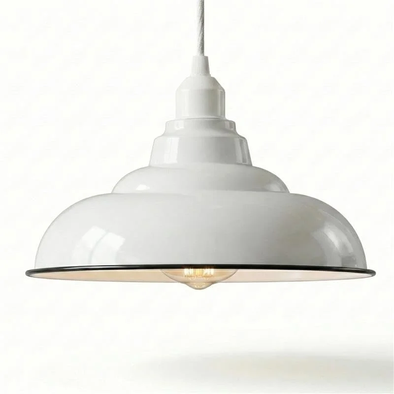 Green metal ceiling light shade with black rim shown hanging against a white background, highlighting its curved design