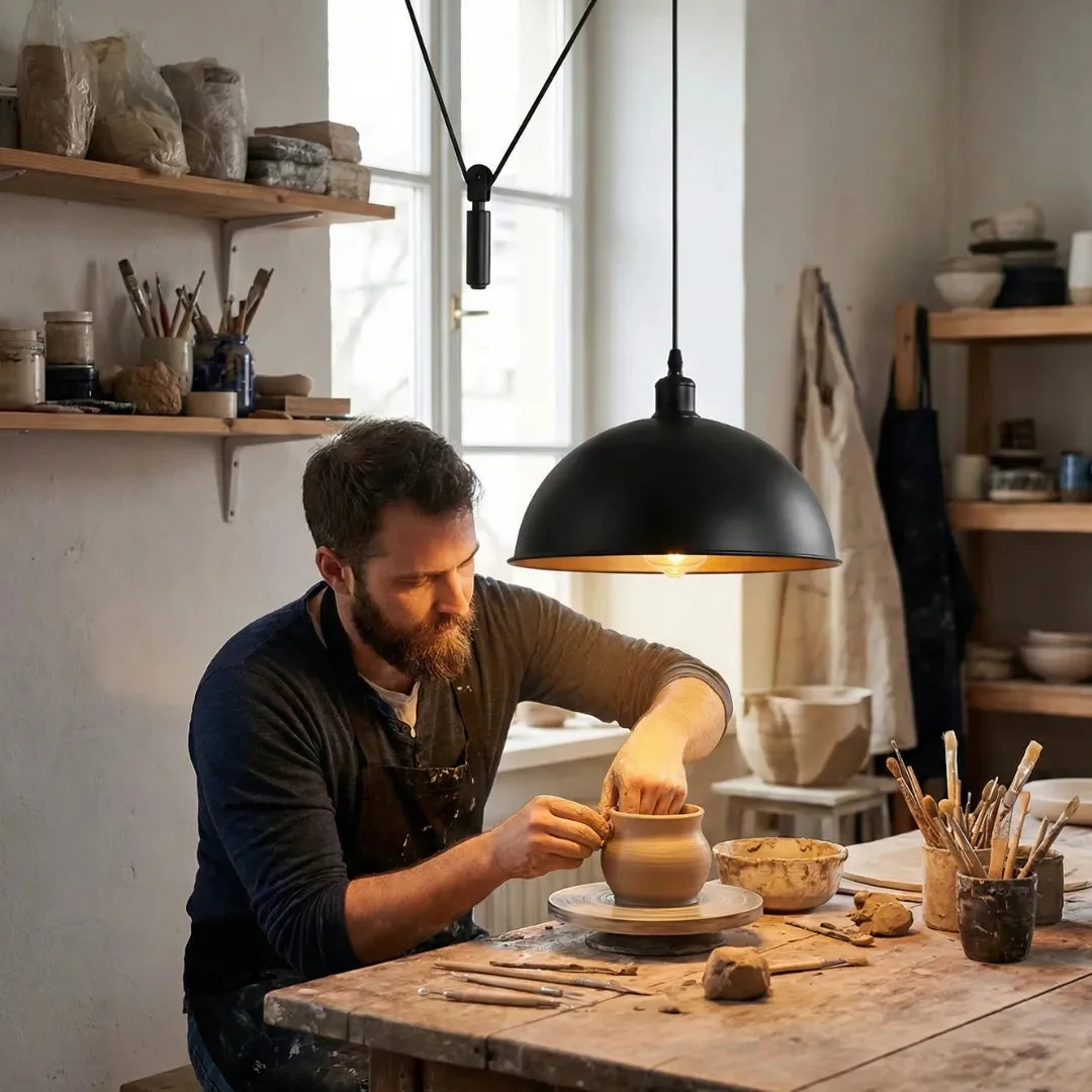 Black industrial pendant light with adjustable rise and fall pulley system and retro dome shade hanging from ceiling