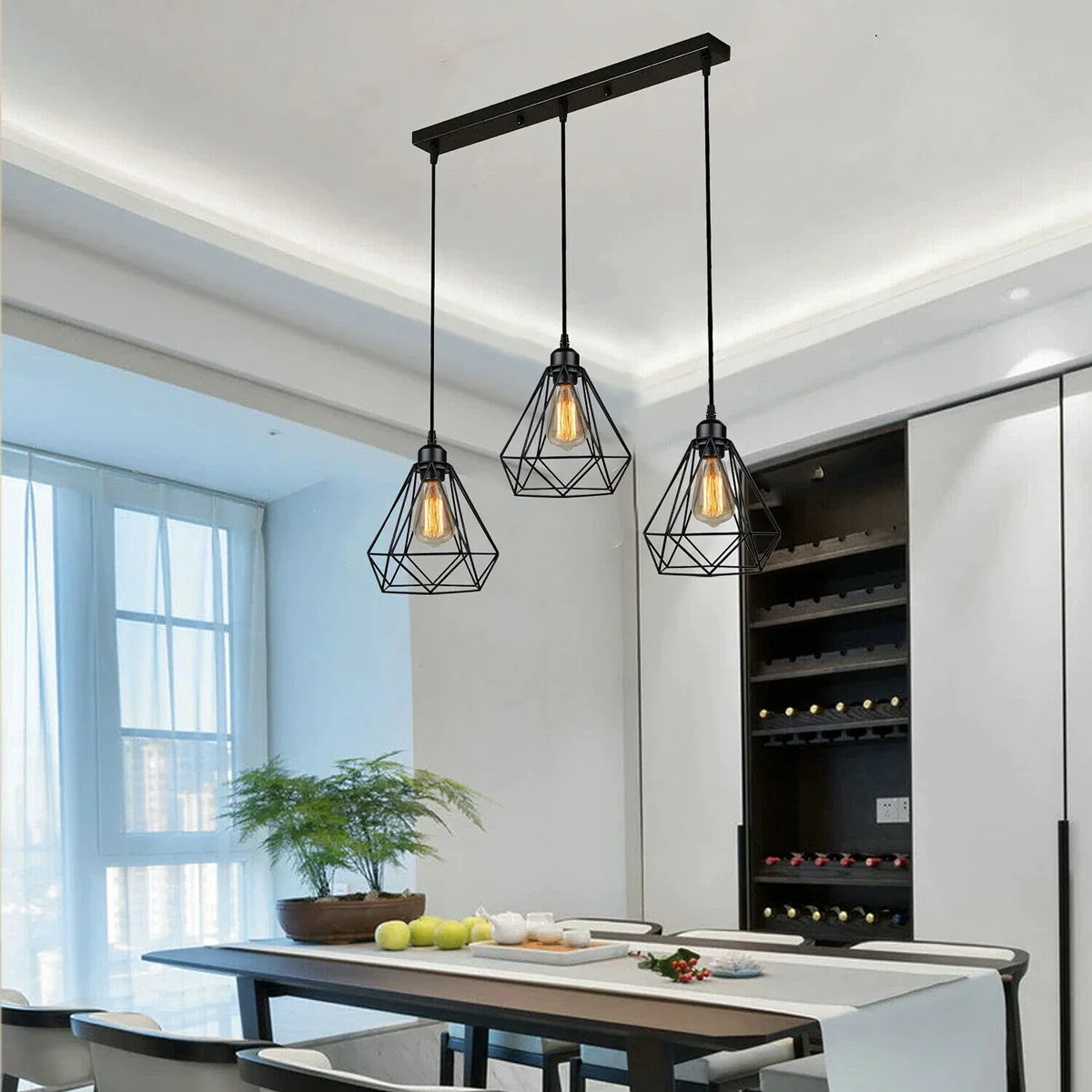 Three black metal cage industrial pendant lights hanging with adjustable cords against a white background