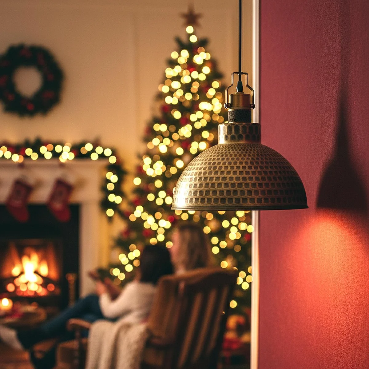 Green brass adjustable pendant light with hammered metal dome shade hanging from adjustable cable against white background