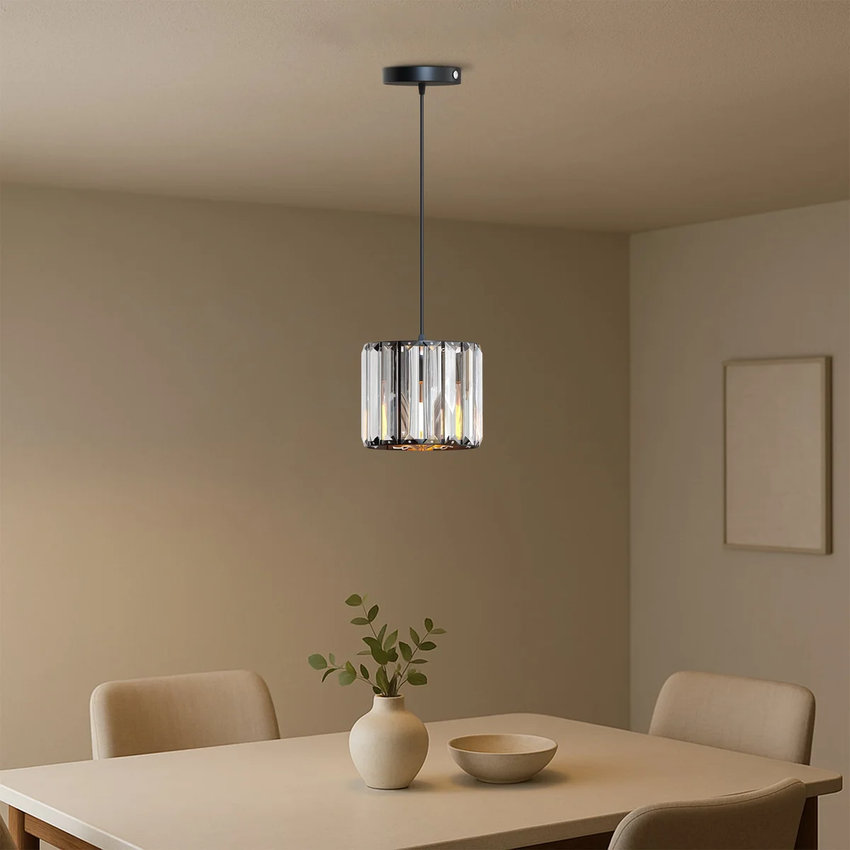 Modern crystal pendant light with drum-shaped crystal shade hanging from metal holder