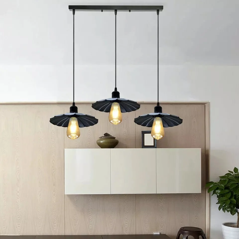 Black vintage industrial pendant light with three metal shades hanging from black PVC cables